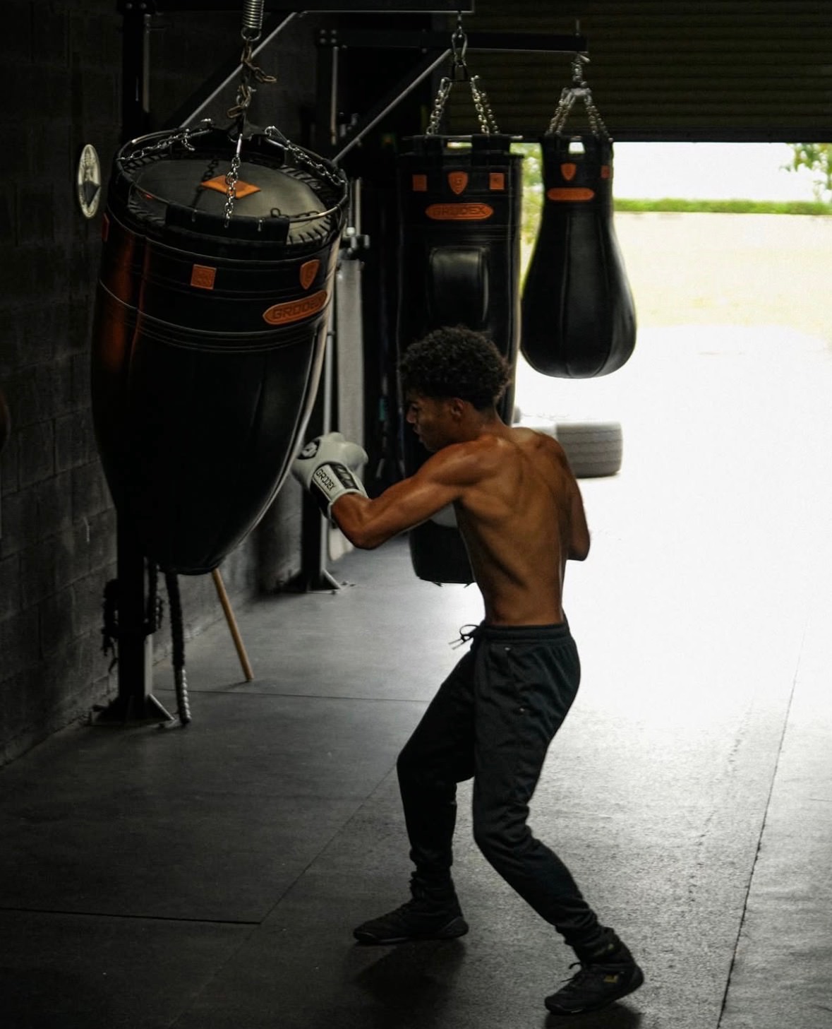 A fighter mid-strike on the heavy bag at Elite K.O. Academy